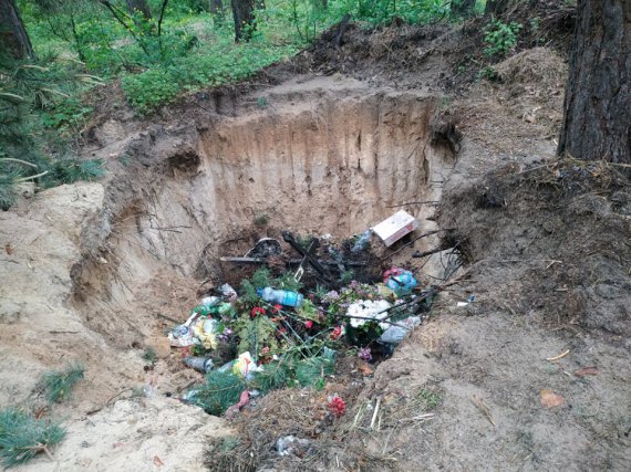 Под Полтавой кладбищенский мусор сбрасывают в огромную яму в лесу (фото)